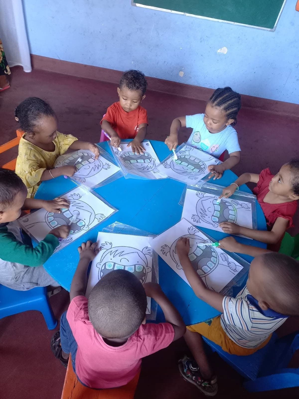 Young children taking part in a coloring activity at Fitiava Academy