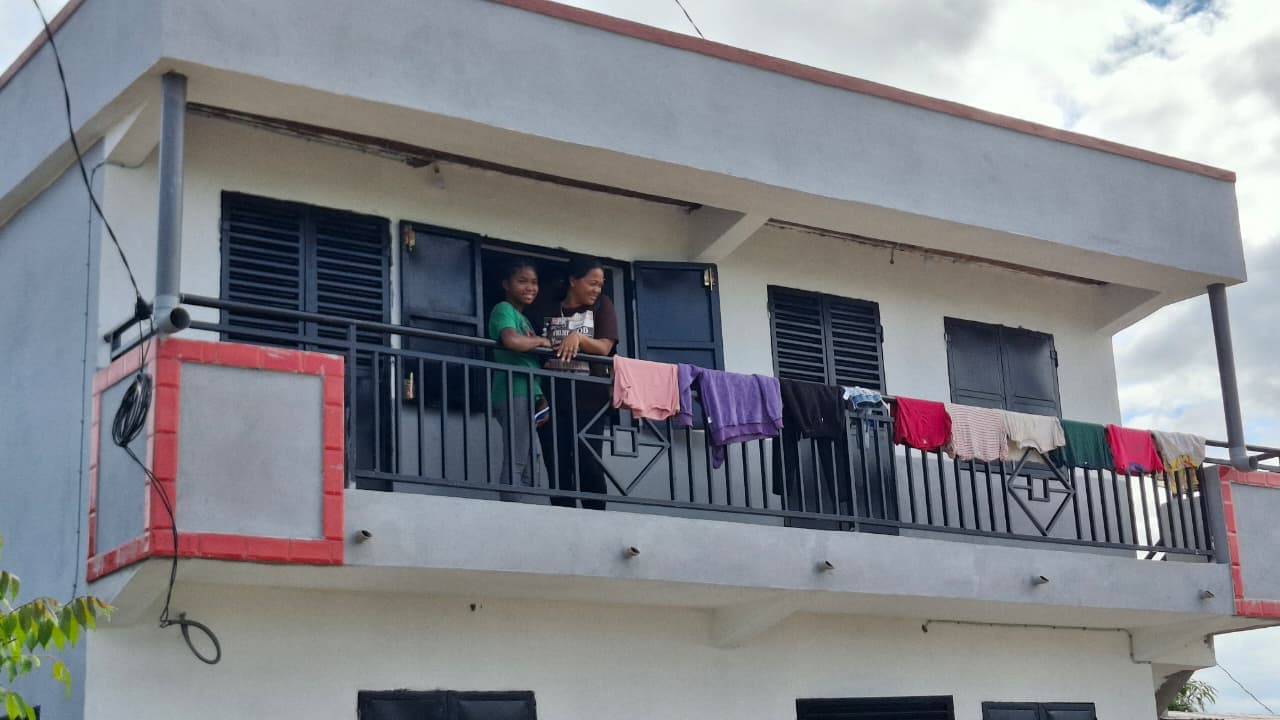 The nearly finished home, with residents on the balcony
